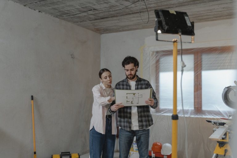 couple devant plan de rénovation intérieur dans maison en travaux